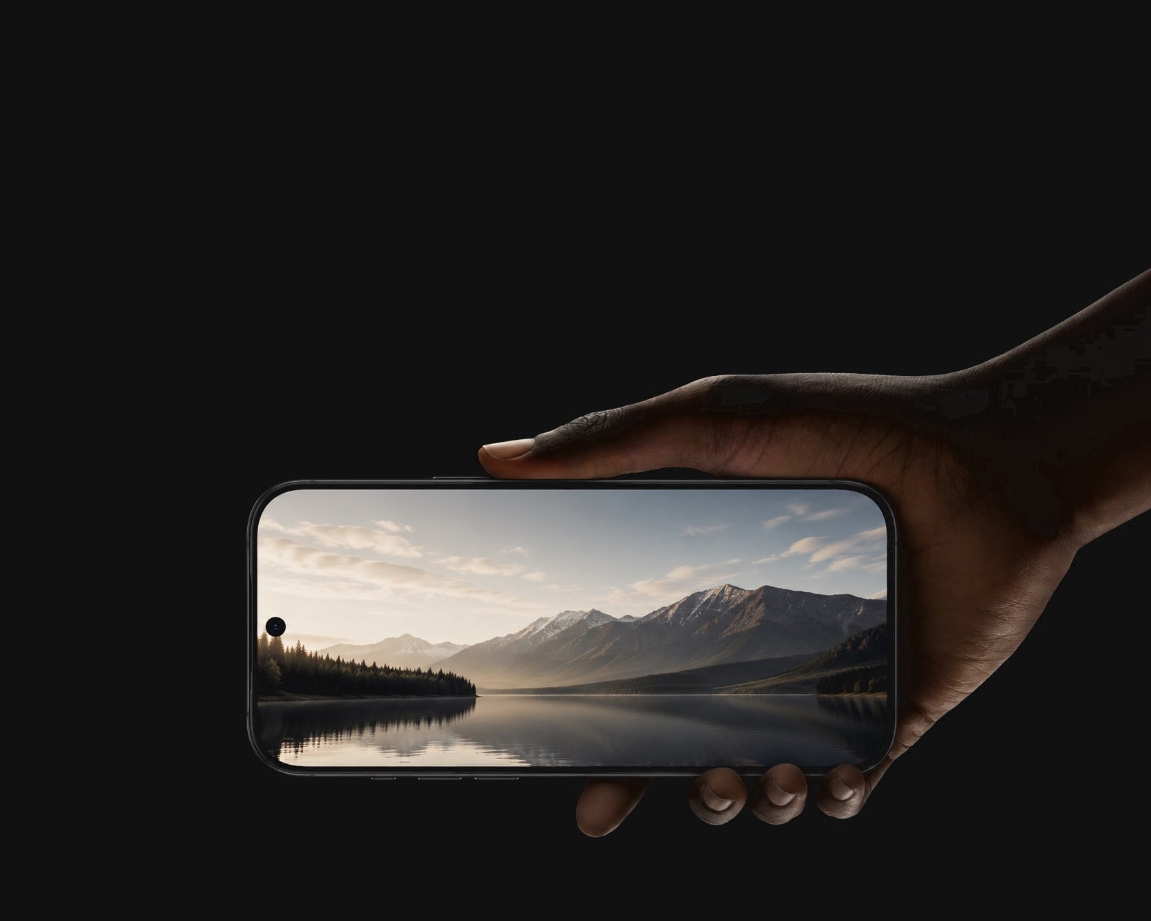 Hand holding a smartphone displaying a scenic view of mountains and a lake.